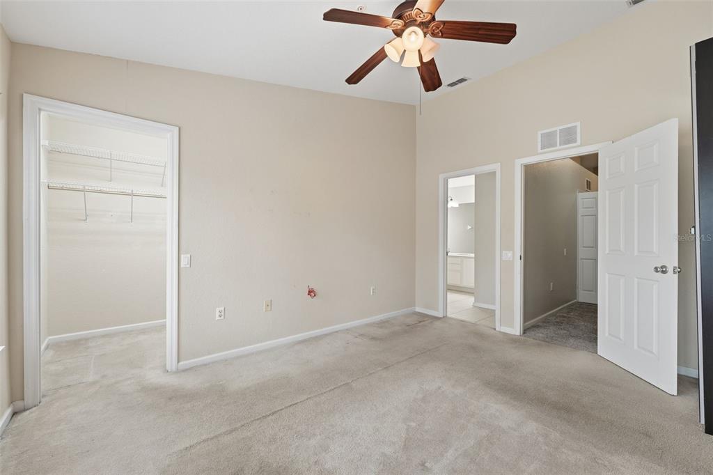 2838 Villafuerte Point, Unit 107 Orlando, FL 32835 - Photo 15 of 27 an empty room with closet and a chandelier fan