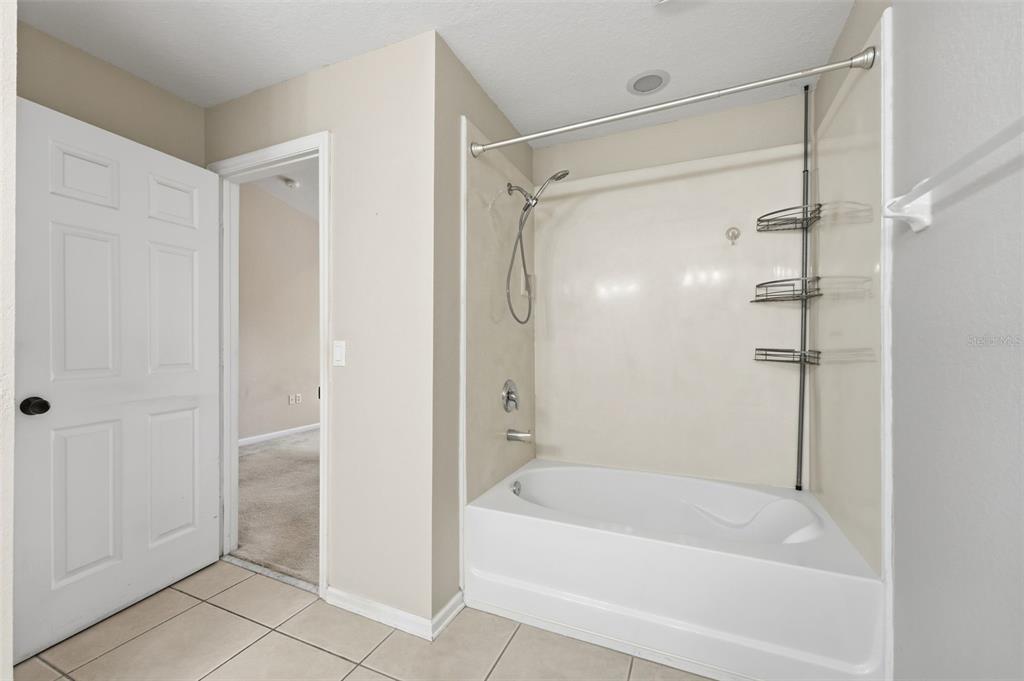 2838 Villafuerte Point, Unit 107 Orlando, FL 32835 - Photo 18 of 27 a bathroom with a bathtub and a shower