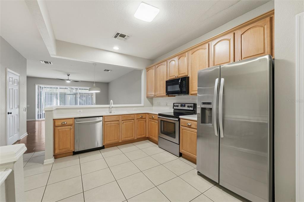 2838 Villafuerte Point, Unit 107 Orlando, FL 32835 - Photo 6 of 27 a kitchen with granite countertop appliances cabinets and furniture