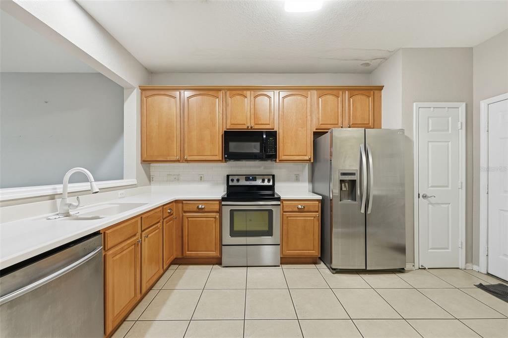 2838 Villafuerte Point, Unit 107 Orlando, FL 32835 - Photo 7 of 27 a kitchen with a refrigerator sink and cabinets