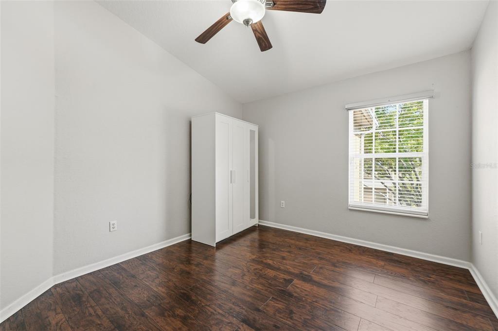 2838 Villafuerte Point, Unit 107 Orlando, FL 32835 - Photo 8 of 27 a view of an empty room with wooden floor and a window