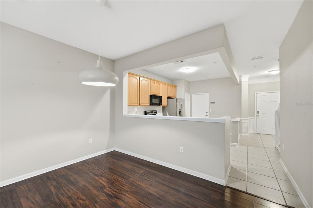 2838 Villafuerte Point, Unit 107 Orlando, FL 32835 - Photo 9 of 27 a view of a hallway with wooden floor and a kitchen