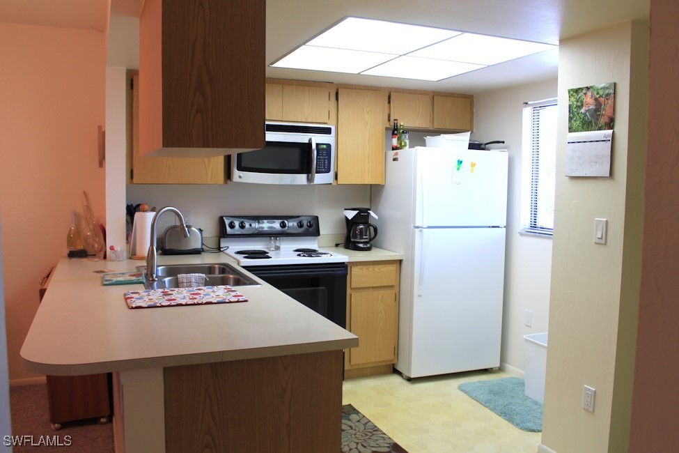 1221 Barrett Road, Unit 905 North Fort Myers, FL 33903 - Photo 5 of 22 a kitchen with a refrigerator a stove top oven a sink and cabinets