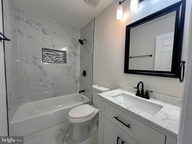 a bathroom with a toilet a sink a bathtub and a mirror