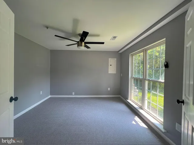a view of a livingroom with a ceiling fan and window