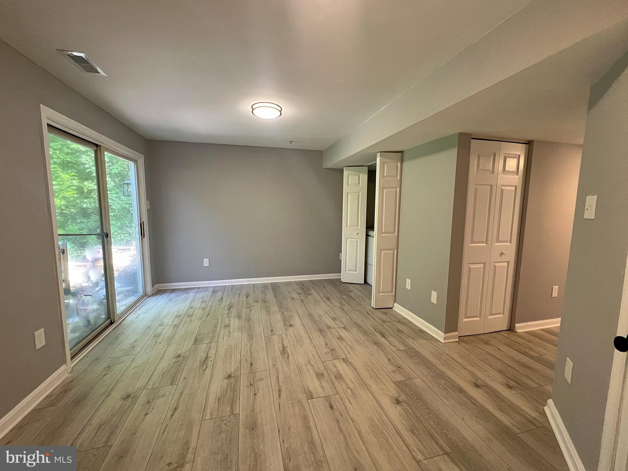 9864 Greenbriar Way Middle River, MD 21220 - Photo 5 of 17 an empty room with wooden floor and windows