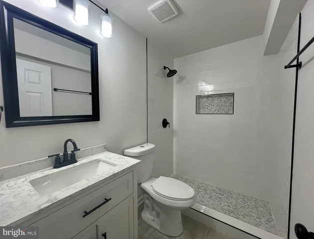 a bathroom with a toilet a sink a mirror and vanity