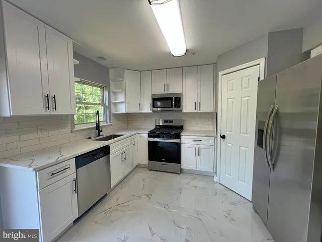 a kitchen with granite countertop a refrigerator and a sink