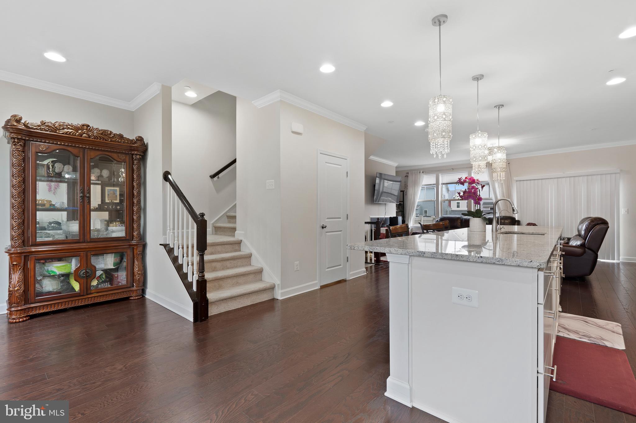 3516 Flatwoods Drive Frederick, MD 21704 - Photo 11 of 41 a kitchen with stainless steel appliances kitchen island granite countertop a stove a refrigerator a sink a dining table and chairs with wooden floor
