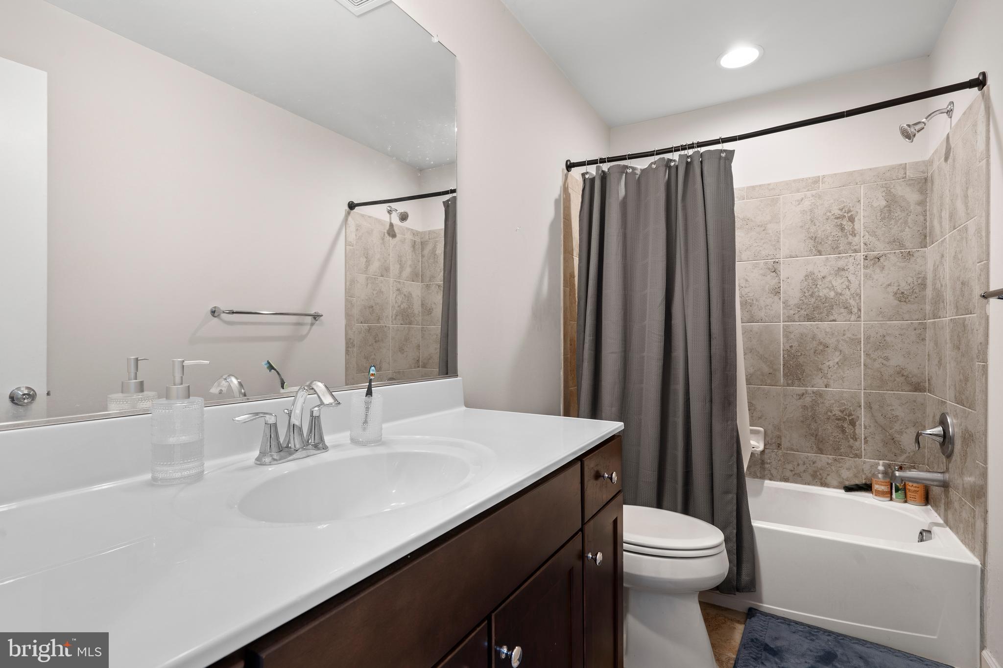 3516 Flatwoods Drive Frederick, MD 21704 - Photo 24 of 41 a bathroom with a sink a toilet a mirror a bathtub and shower