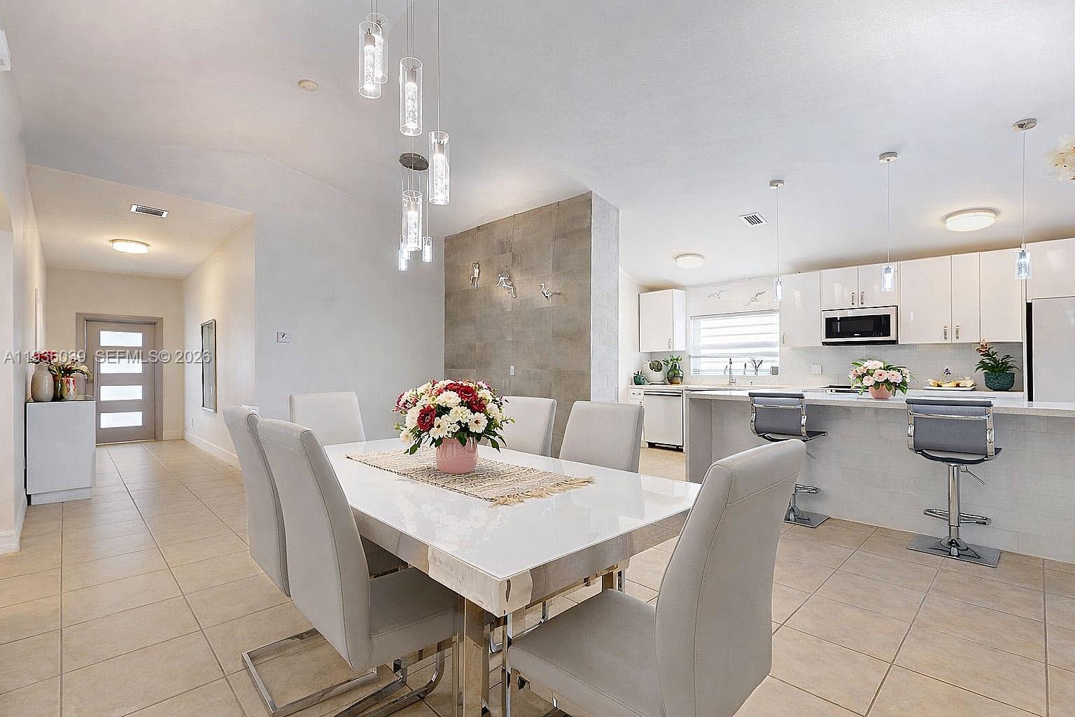2625 40th Avenue Southeast Naples, FL 34117 - Photo 11 of 81 a view of a dining room and livingroom with furniture wooden floor a chandelier