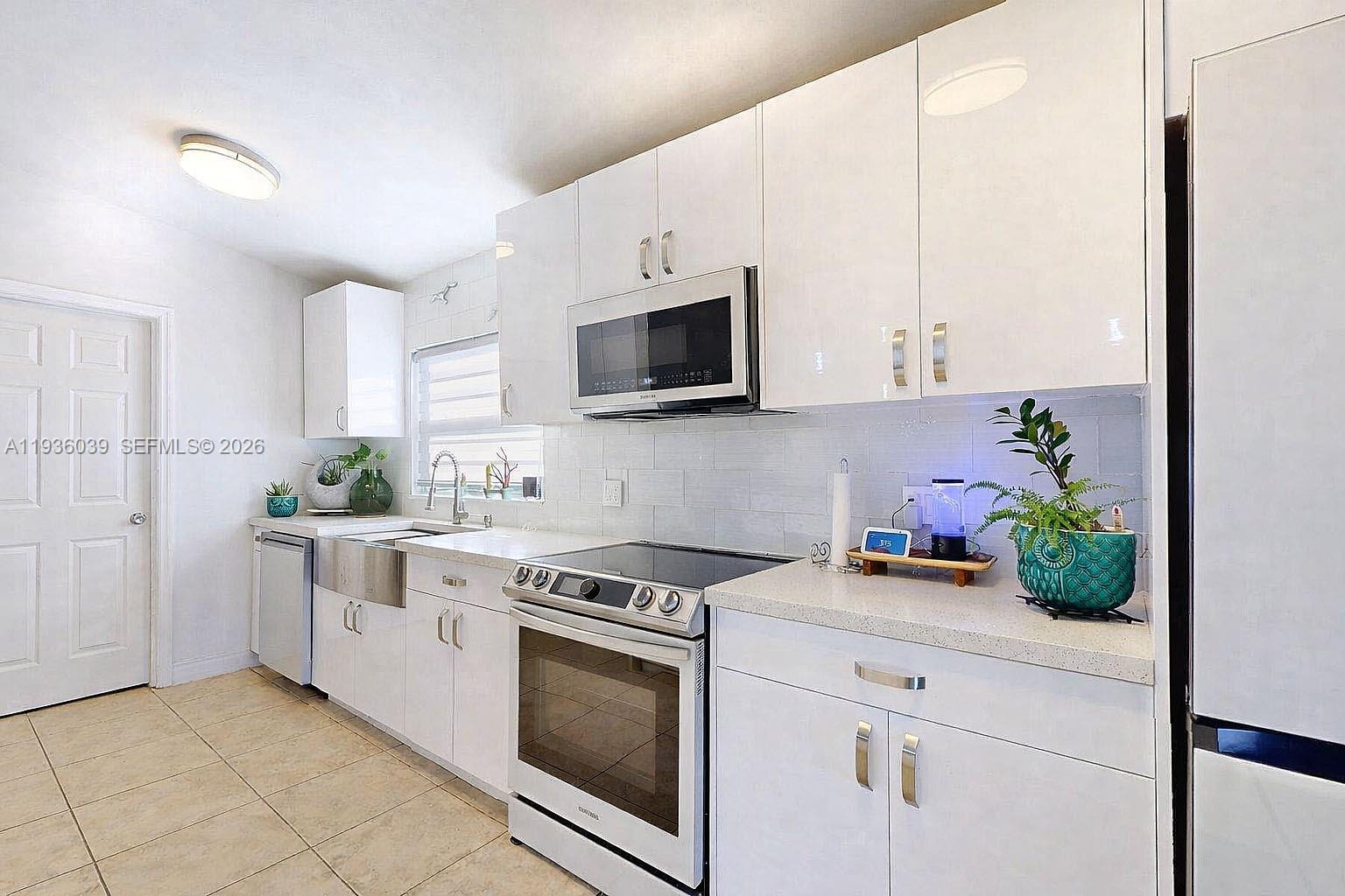 2625 40th Avenue Southeast Naples, FL 34117 - Photo 16 of 81 a kitchen with stainless steel appliances white cabinets and a stove