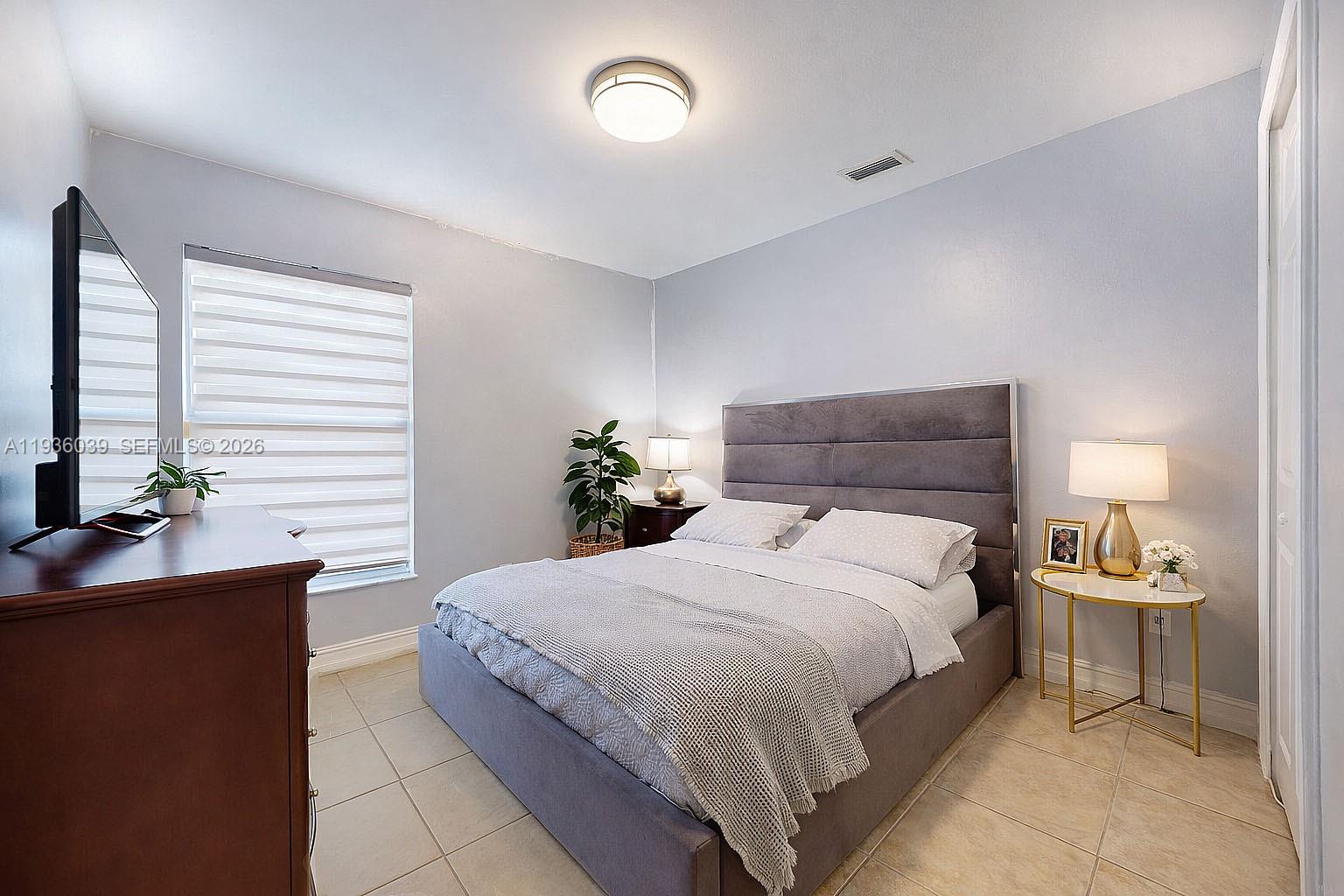 2625 40th Avenue Southeast Naples, FL 34117 - Photo 25 of 81 a bedroom with a bed and a table in it