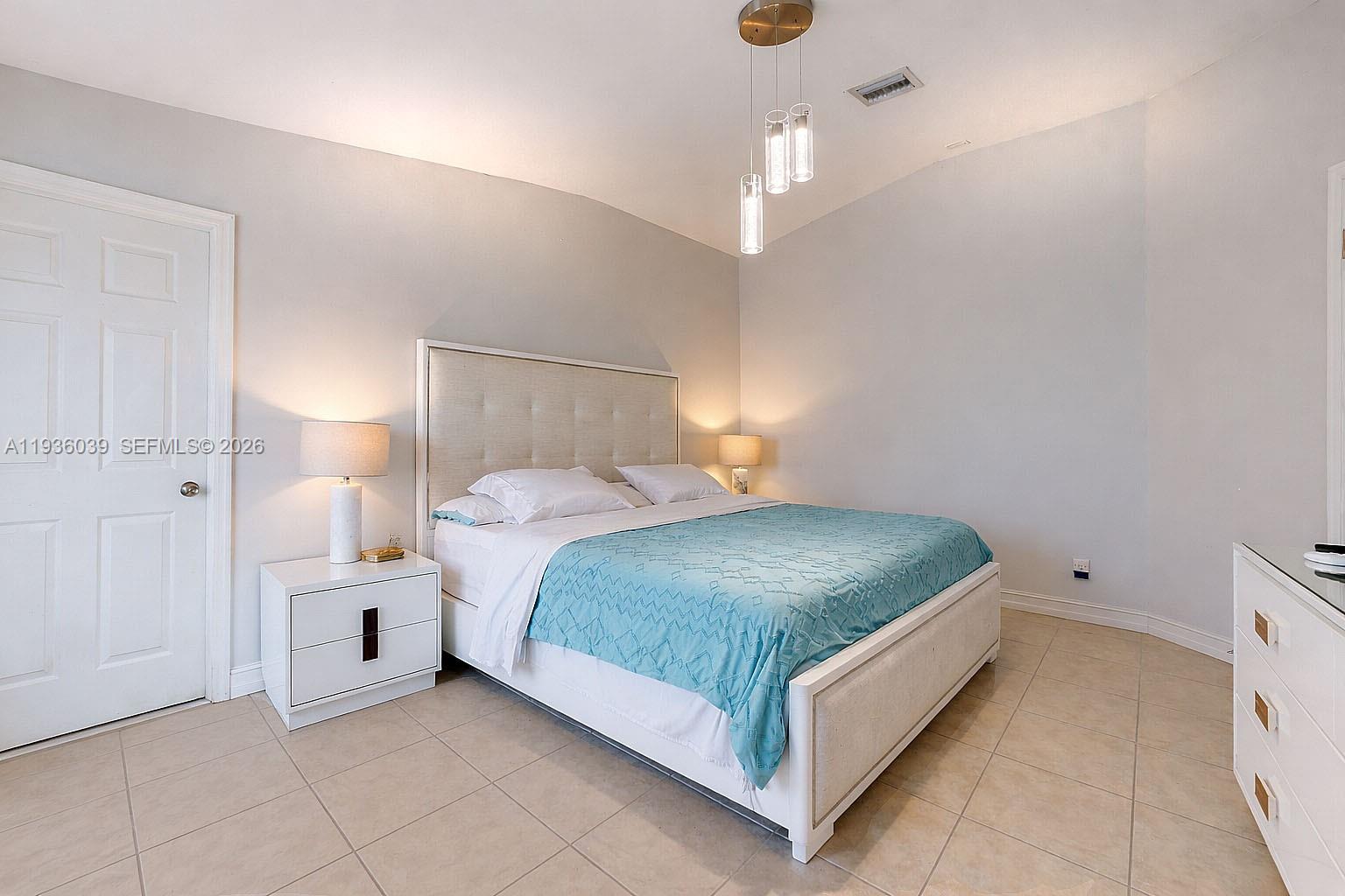 2625 40th Avenue Southeast Naples, FL 34117 - Photo 39 of 81 a bedroom with a bed and a chandelier