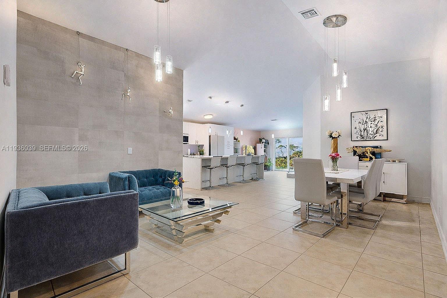 2625 40th Avenue Southeast Naples, FL 34117 - Photo 7 of 81 a living room with couches and a dining table with kitchen view