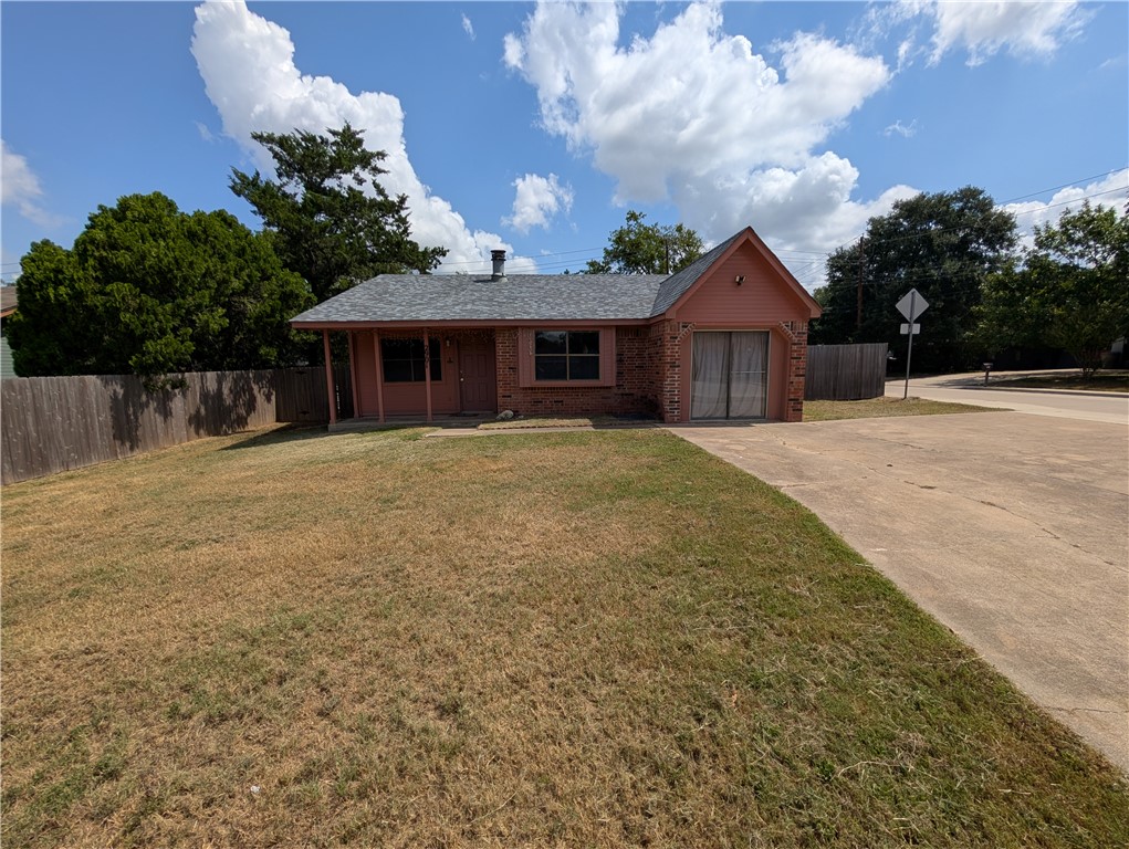 View of front of house featuring driveway, brick siding, and roof with shingles