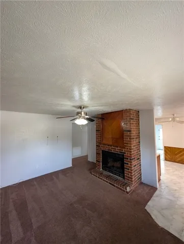 an empty room with fireplace and fan