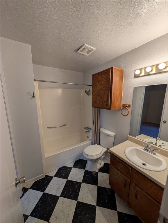2901 Minnesota Avenue Bryan, TX 77803 - Photo 10 of 16 Bathroom featuring shower / tub combo with curtain, vanity, a textured ceiling, and dark floors