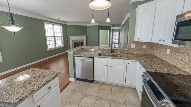 a kitchen with granite countertop a sink stove and cabinets