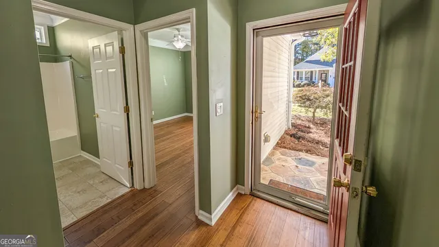 a view of a bathroom with wooden floor and a glass door