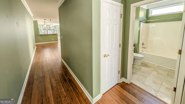 a view of a hallway with wooden floor and staircase