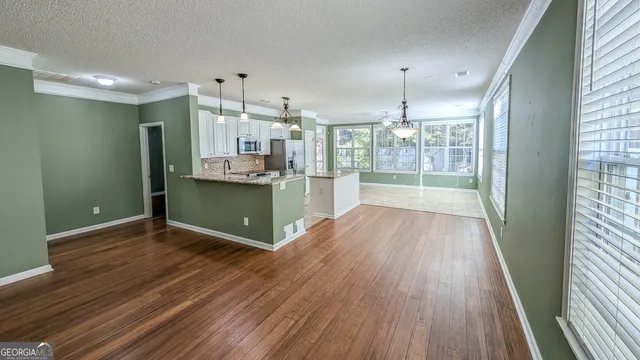 a view of a kitchen with wooden floor and outdoor space