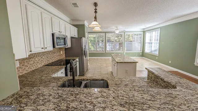 a kitchen with granite countertop a sink and a window