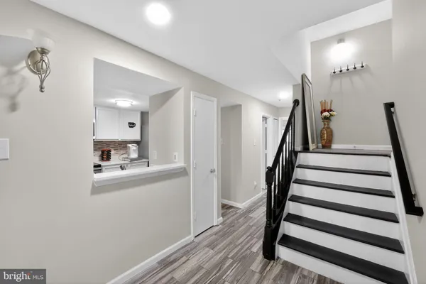 a view of a hallway with wooden floor and staircase