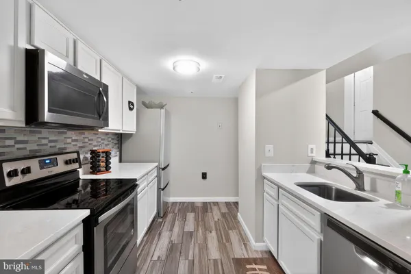 a kitchen that has a sink and a stove top oven