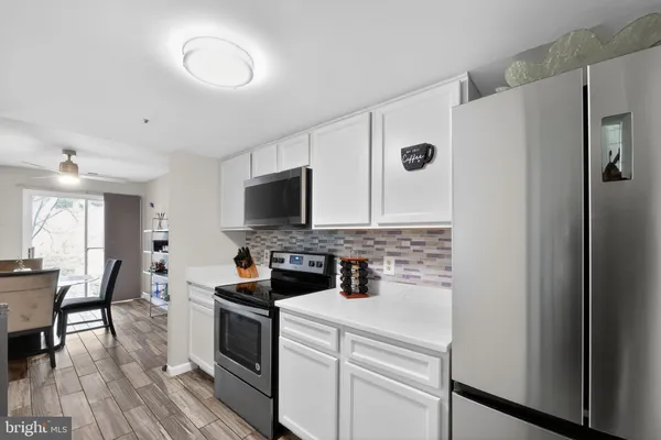 a kitchen with a refrigerator stove and wooden floor