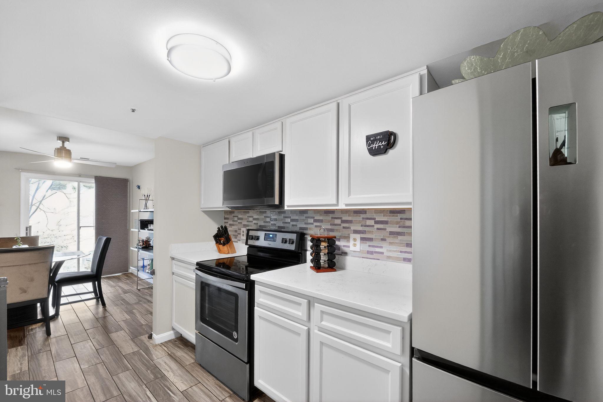 14229 Jib Street, Unit 12 Laurel, MD 20707 - Photo 7 of 17 a kitchen with a refrigerator stove and wooden floor