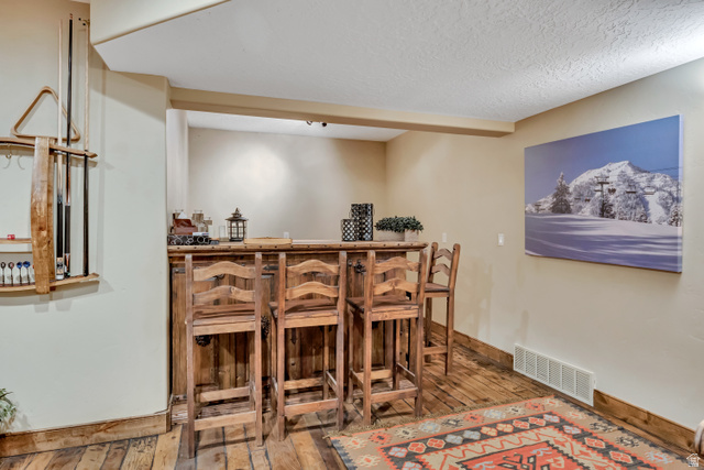 9049 Timphaven Road Sundance, UT 84604 - Photo 46 of 63 Indoor wet bar featuring hardwood / wood-style flooring and a textured ceiling