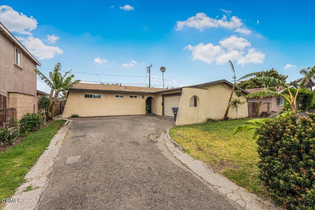970 Laurel Street West Oxnard, CA 93033 - Photo 2 of 40 a front view of a house with a yard and garage