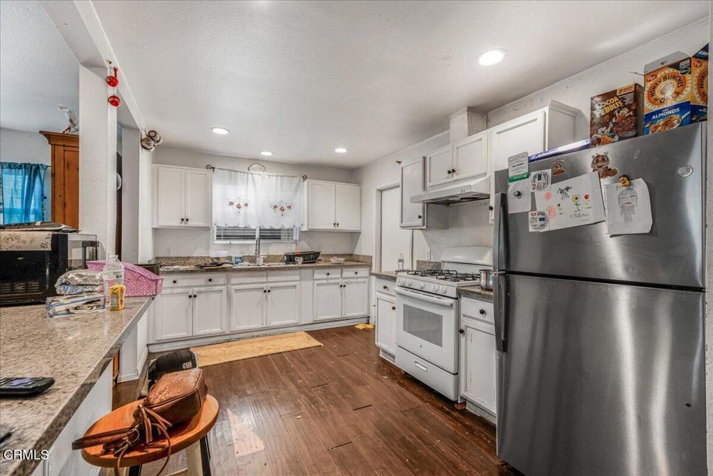 970 Laurel Street West Oxnard, CA 93033 - Photo 6 of 40 a kitchen with stainless steel appliances granite countertop a refrigerator a stove a sink dishwasher and a refrigerator with wooden floor