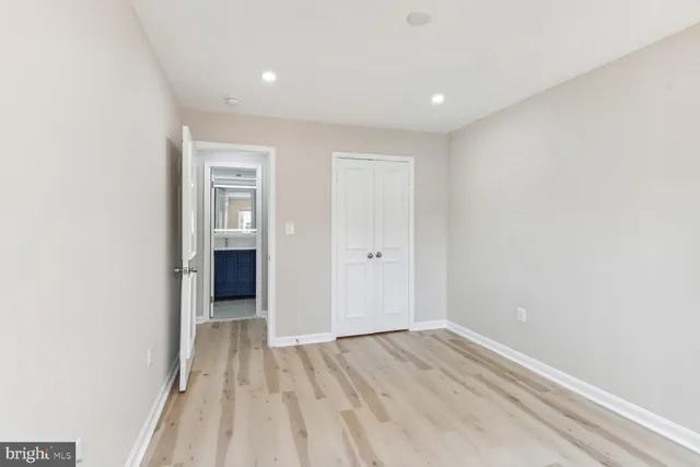 an empty room with wooden floor and closet