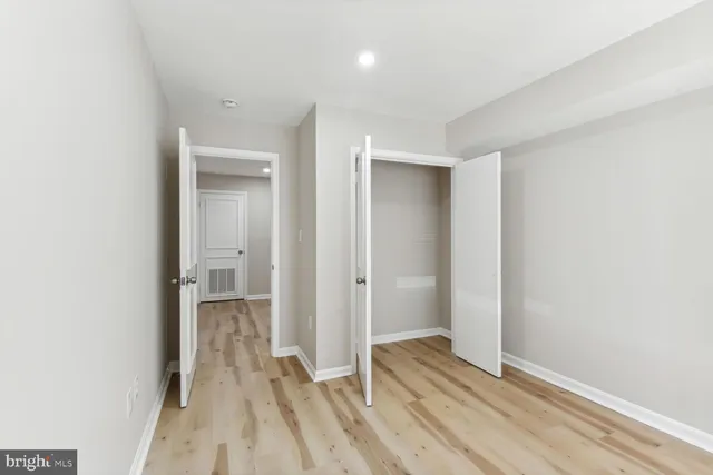 an empty room with wooden floor and window