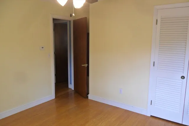 an empty room with closet and wooden floor