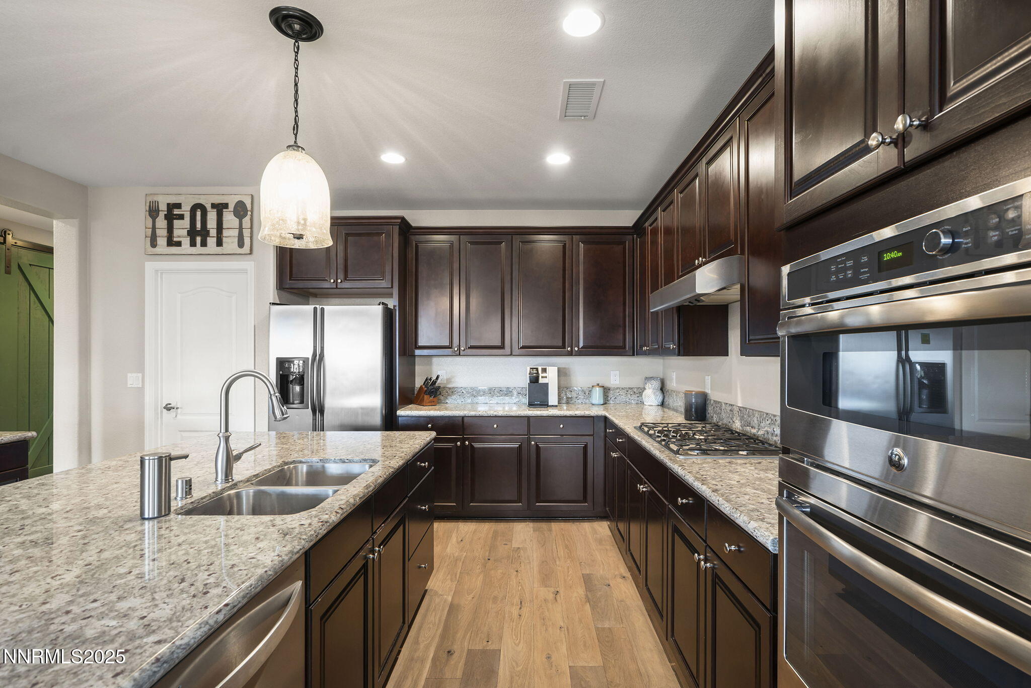 2835 Tobiano Drive Reno, NV 89521 - Photo 14 of 33 a kitchen with stainless steel appliances granite countertop a sink a stove and a wooden floors