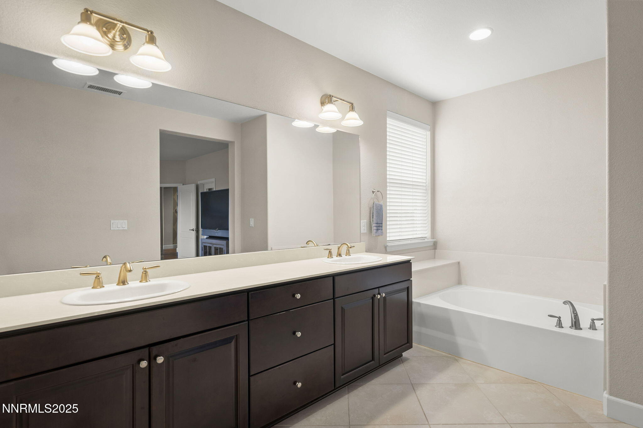 2835 Tobiano Drive Reno, NV 89521 - Photo 19 of 33 a bathroom with a double vanity sink bathtub and a mirror