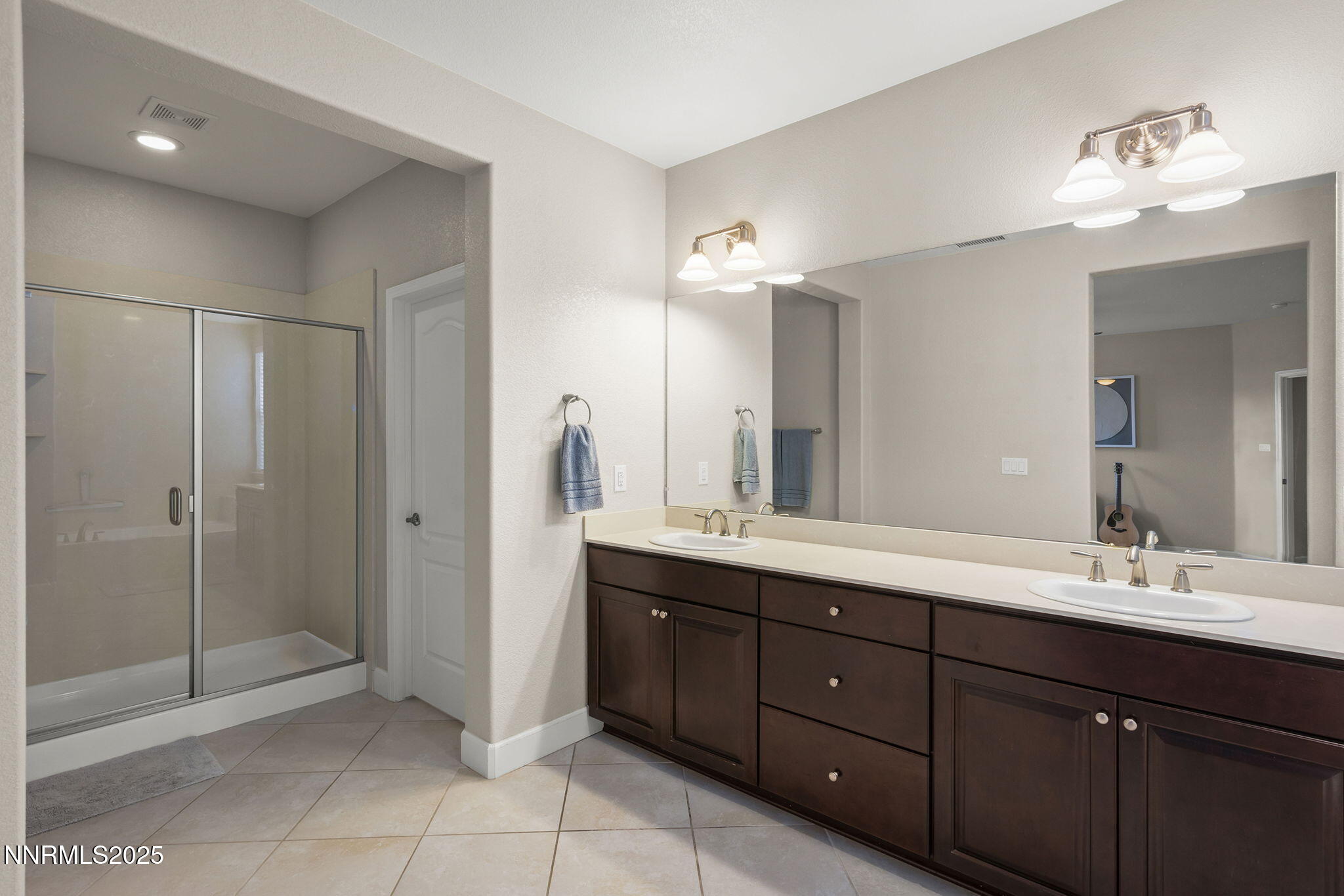 2835 Tobiano Drive Reno, NV 89521 - Photo 20 of 33 a bathroom with a double vanity sink a large mirror and shower