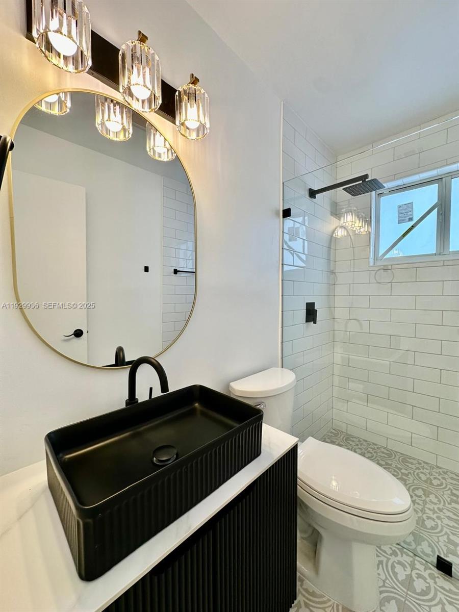 629 Southwest 4th Street Hallandale Beach, FL 33009 - Photo 12 of 27 a bathroom with a sink a toilet and mirror