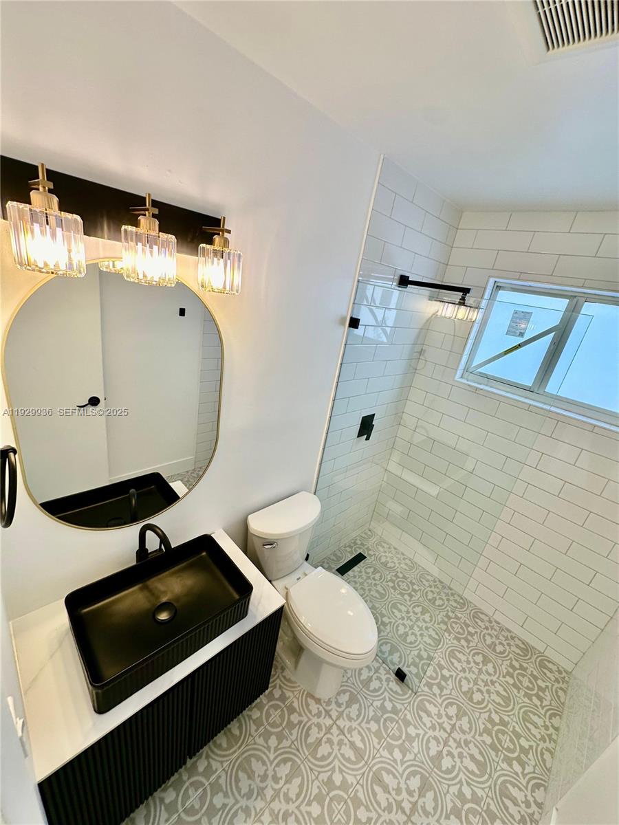 629 Southwest 4th Street Hallandale Beach, FL 33009 - Photo 13 of 27 a bathroom with a sink a toilet and shower