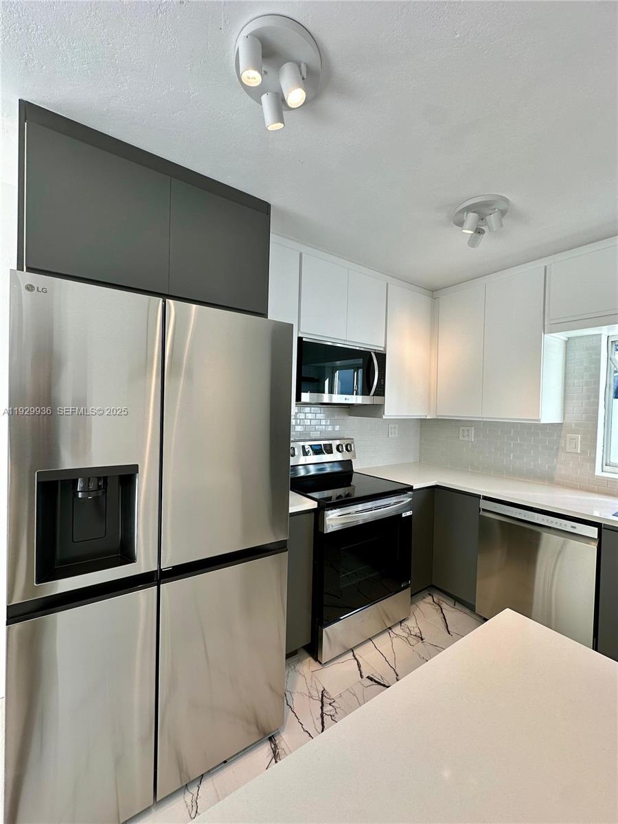 629 Southwest 4th Street Hallandale Beach, FL 33009 - Photo 9 of 27 a kitchen with stainless steel appliances a refrigerator sink and microwave