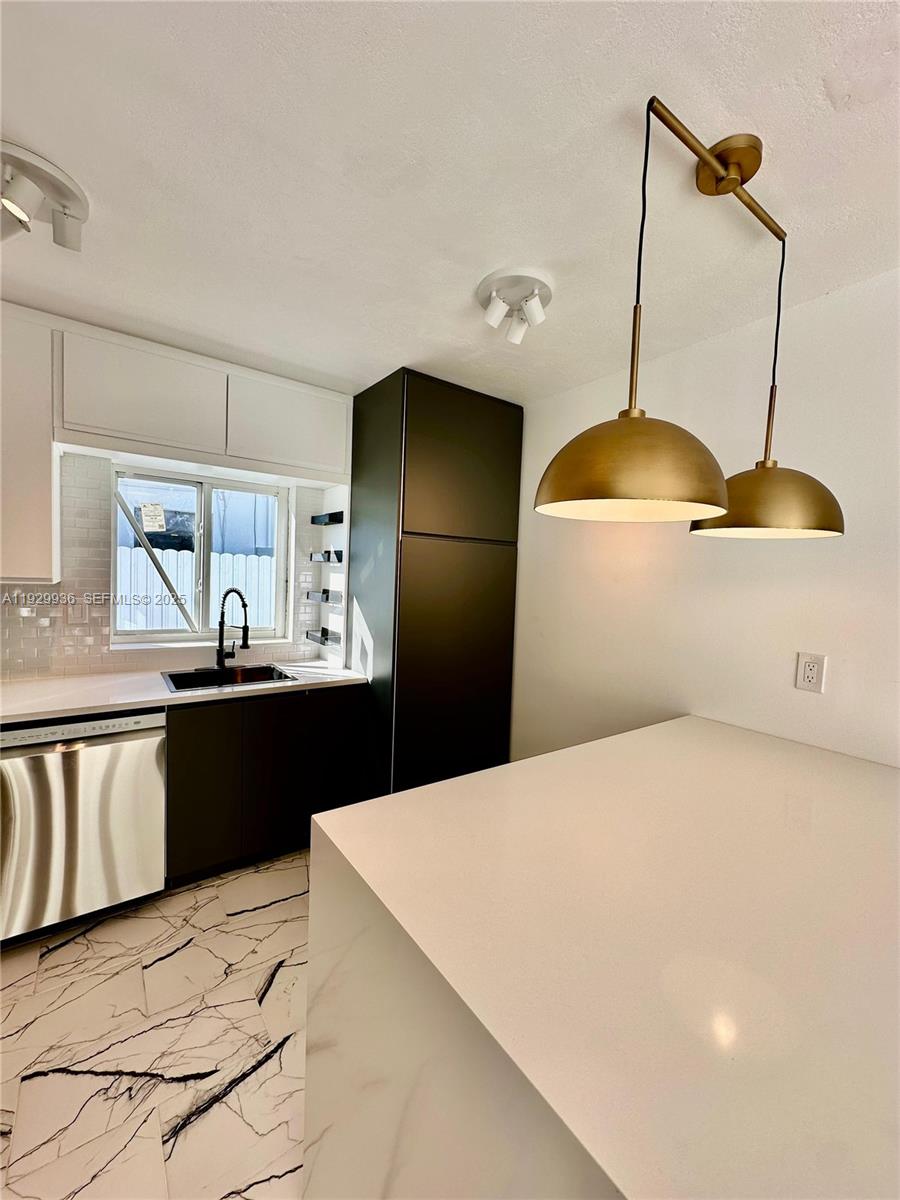 629 Southwest 4th Street Hallandale Beach, FL 33009 - Photo 10 of 27 a kitchen with stainless steel appliances a stove a refrigerator a sink a counter space and wooden floor