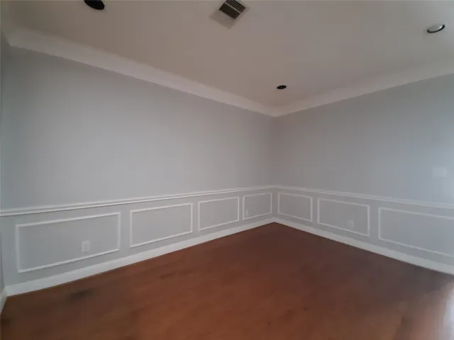 a view of an empty room with kitchen and fireplace