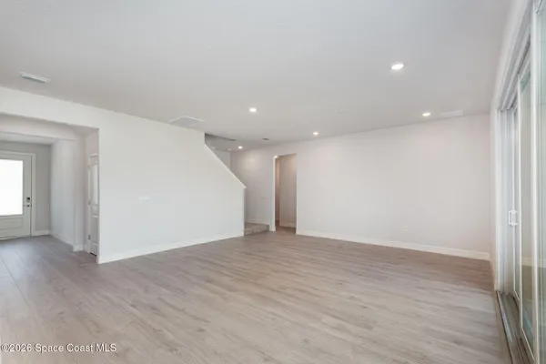 a view of an empty room with wooden floor