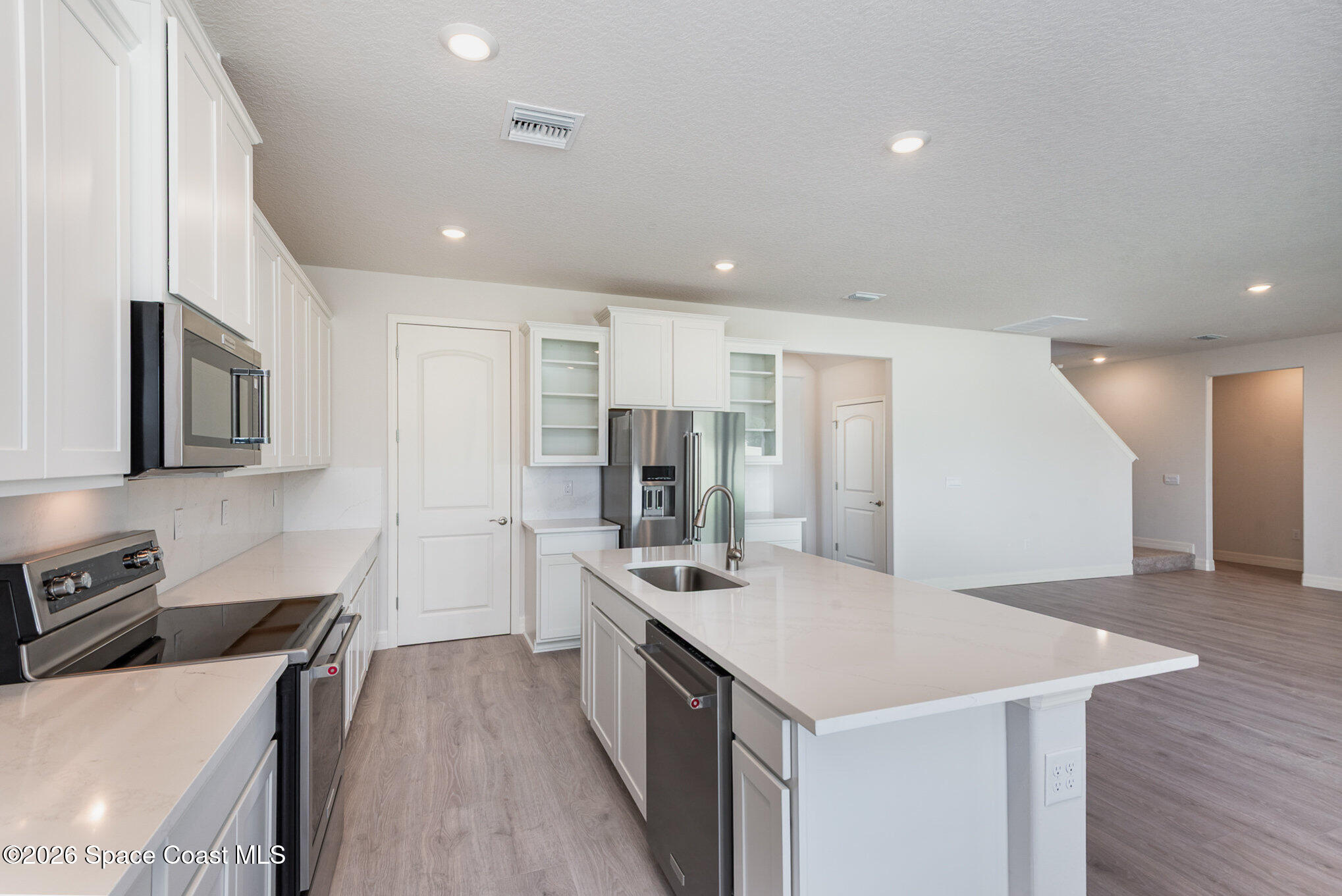 150 First Light Circle Cocoa, FL 32922 - Photo 10 of 28 a kitchen that has a lot of cabinets a sink and a wooden floor