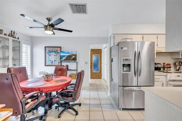 a dining room with stainless steel appliances a dining table and chairs
