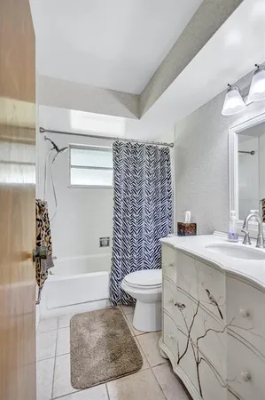 a bedroom with a large bed and a flat tv screen on dresser