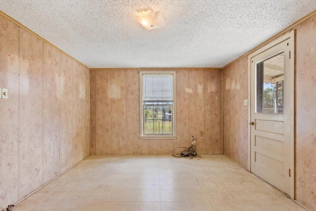 100 County Road 120 C Riesel, TX 76682 - Photo 11 of 25 Spare room featuring tile patterned floors and a textured ceiling